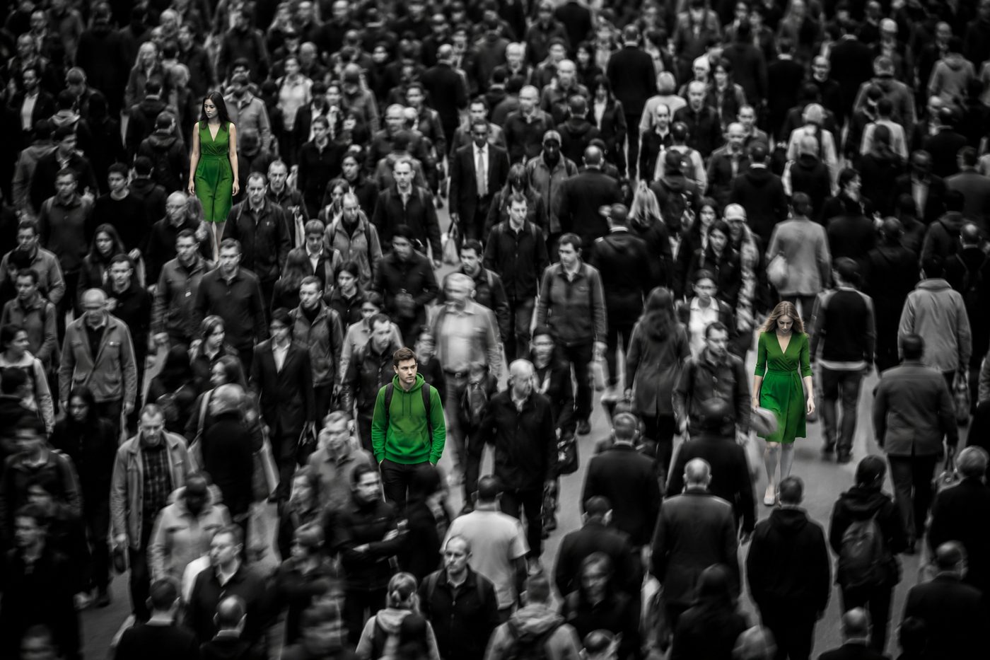Una multitud caminando; tres personas destacan en verde entre el gentío